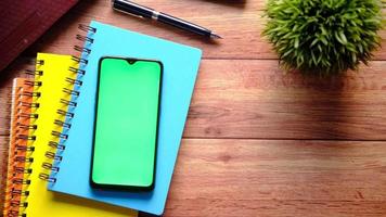 Top view of smart phone and notepad on table video