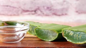 Primer plano de aloe vera fresco en rodajas y aceite en un recipiente sobre una tabla de cortar video