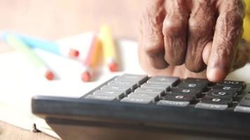 senior vrouw hand- gebruik makend van rekenmachine Aan bureau video