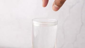 Dropping Effervescent soluble tablet pills in a glass of water video