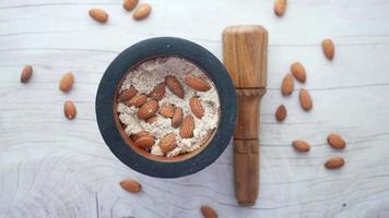 Almond powder and almond in a wooden jar on table
