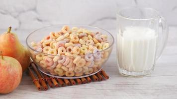 Colorful cereal, apple and glass of milk on table video