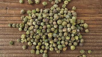 Dried green peppercorn. Dry green pepper spice on wooden table. video