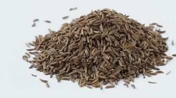 Pile of cumin seeds isolated on white background video