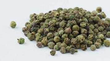 Dried green peppercorn seeds on white background video