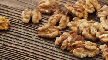 Raw walnut kernels on wooden table video