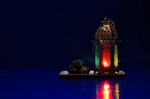 Lantern and dates fruit put on table with dark blue background for the Muslim feast of the holy month of Ramadan Kareem. photo