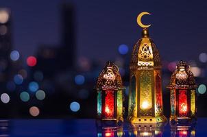 Selective focus on big lantern with night sky and city bokeh light background for the Muslim feast of the holy month of Ramadan Kareem. photo