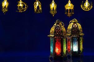 dorado linternas poner en oscuro azul antecedentes con decorado luces para el musulmán banquete de el santo mes de Ramadán kareem foto