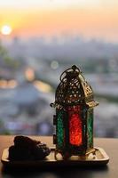 Lantern and dates fruit with dusk sky and city background for the Muslim feast of the holy month of Ramadan Kareem. photo