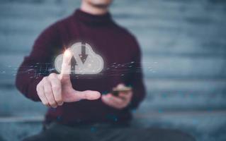 man sitting outdoor and working with cloud computing diagram show on hand. Cloud technology. Data storage. Networking and internet service concept. photo
