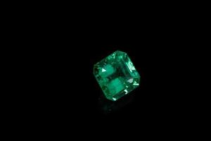 Macro mineral Emerald gemstone faceted on black background photo