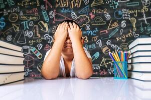 Child sitting with hands close his eyes in the classroom photo