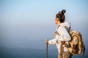 el retrato de una joven turista asiática está caminando en la cima del montaje y mirando un hermoso paisaje con espacio para copiar foto