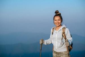 retrato de asiático caminante mujer con mochila mirando a cámara en montaña con Copiar espacio foto