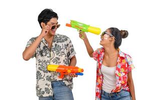 retrato joven pareja disfruta con pistola de agua en el festival de songkran foto