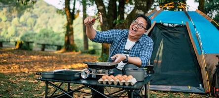 Portrait of Asian traveler man glasses pork steak frying photo