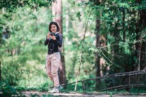 una mujer bonita joven usa una cámara para tomar fotos en un parque natural