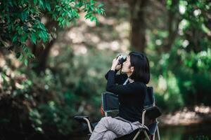 Young pretty woman use camera taking photo in nature park