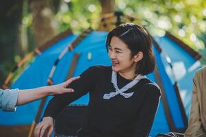 Young woman cooking with egg while camping with girl friend photo