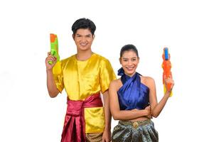 pareja joven disfruta con pistola de agua en el festival songkran foto