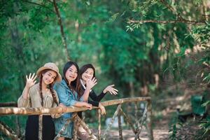 grupo de mujeres jóvenes que buscan una hermosa naturaleza mientras acampan en el bosque foto