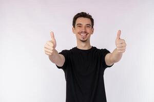Portrait of happy smiling young man showing thumbs up gesture and looking at camera on isolated over white background photo