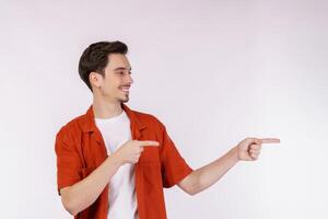 Portrait of young man pointing fingers at copy space isolated on white studio background photo