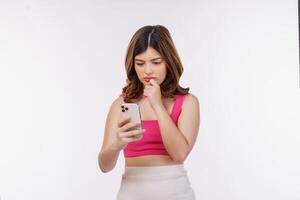 Retrato de mujer joven confundida a través de teléfono móvil aislado sobre fondo blanco. foto