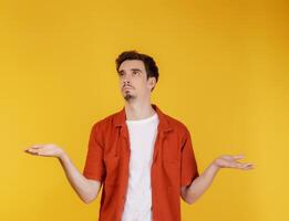Portrait of puzzled clueless young man arms out asking why what's the problem who cares so what, I don't know photo