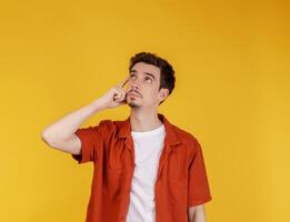 Portrait of thinking man surrounded by question mark on isolated background photo