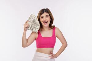 retrato de una joven emocionada sosteniendo un montón de billetes de dólares aislados sobre fondo blanco foto