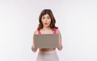 Portrait of excited young woman working on laptop computer isolated over white background photo