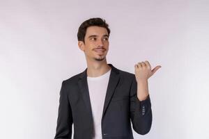 Portrait of young businessman pointing fingers at copy space isolated on white studio background photo