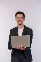 retrato de un joven y apuesto hombre de negocios sonriente sosteniendo una laptop en las manos, escribiendo y navegando por páginas web aisladas de fondo blanco foto