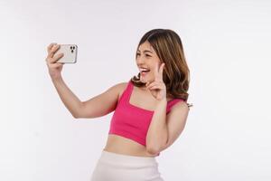 Portrait of happy smiling young woman selfie with smartphone isolated over white background photo