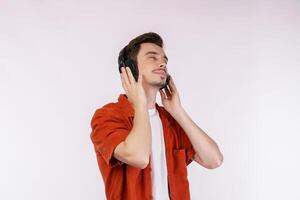 Portrait of happy young man wearing headphone and enjoy music over white background photo