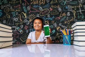 Child sitting and showing mobile in the classroom photo