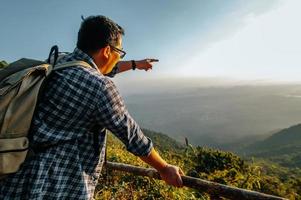 Young trekking man standing point on view point in forest photo