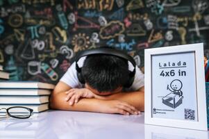 niño sentado y durmiendo con marco de fotos en el aula