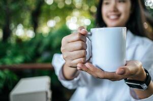 Woman holding a white glass photo