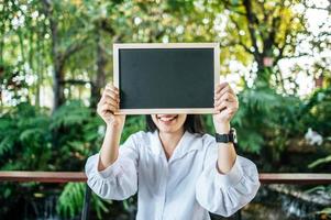 woman holding blank blackboard photo