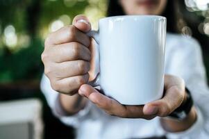 Woman holding a white glass photo