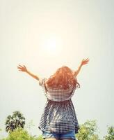 joven mujer aumento su manos dentro el cielo con amanecer entonces fresco. foto