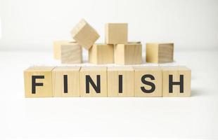 wooden cube block with finish business word on table background. photo