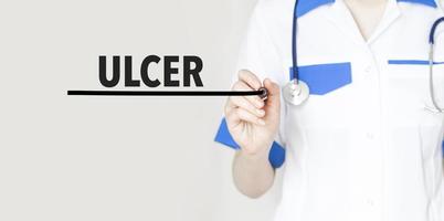 Doctor writing text ulcer with marker, medical concept photo