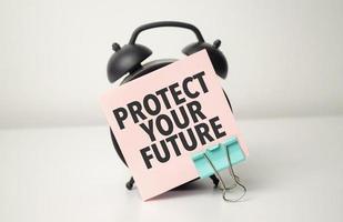 alarma reloj con rosado pegatina con el texto proteger tu futuro foto