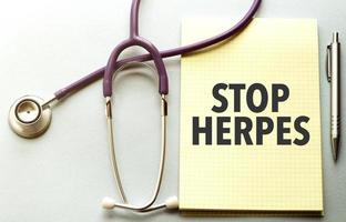 On a purple background a stethoscope with yellow list with text stop herpes photo