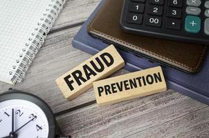 fraud prevention symbol. Concept words pay off debts on wooden blocks photo