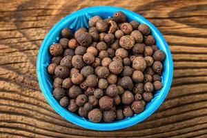 Allspice spice in a small bowl on the table photo